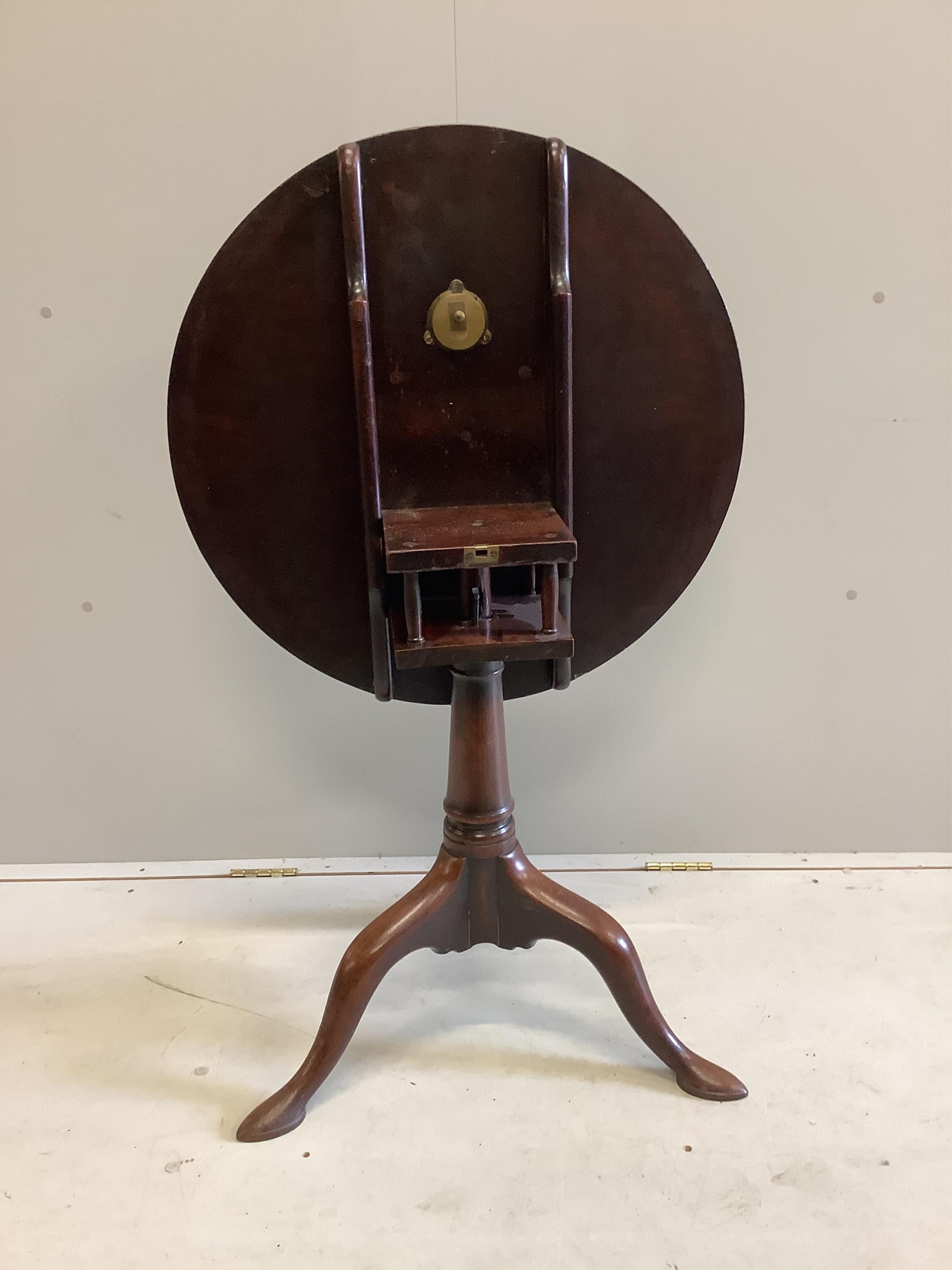 A George III circular mahogany tilt top bird cage tripod tea table, diameter 69cm, height 69cm. Condition - fair